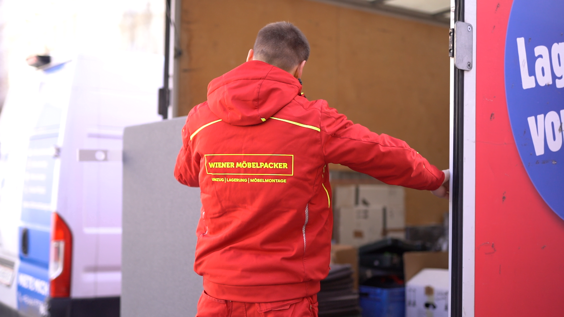 Möbelpacker transportiert Gegenstand in Umzugswagen